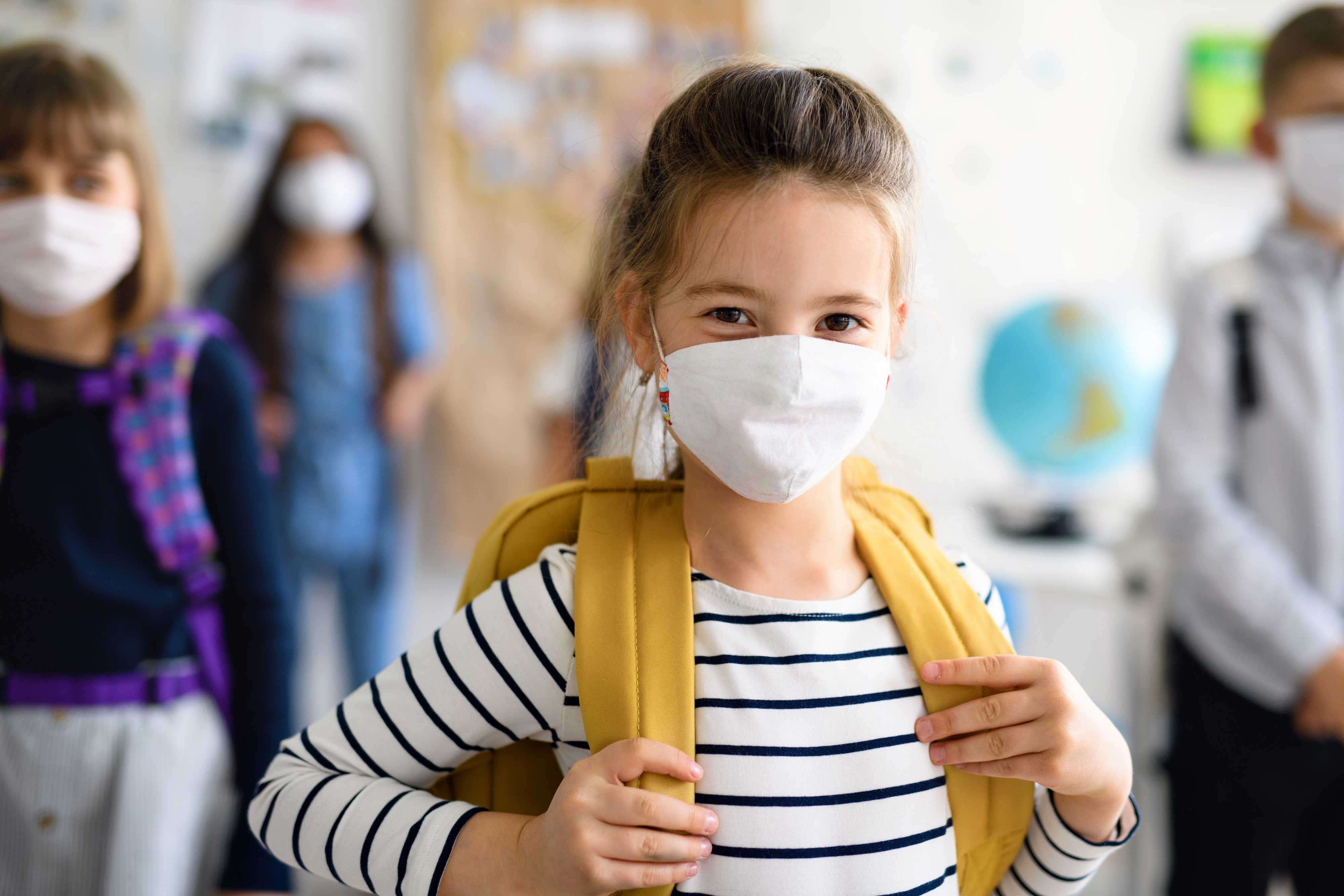 Elementary school student with mask and backpack