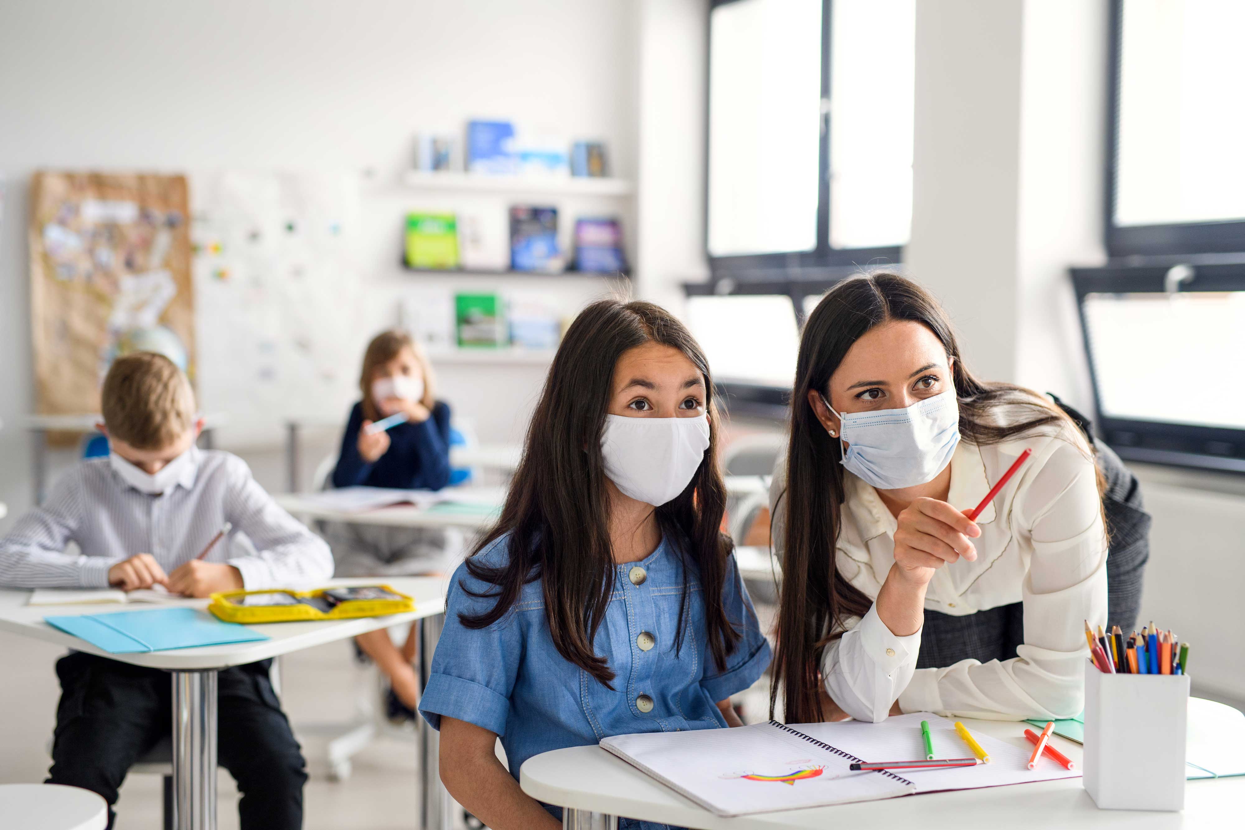 Interaction between a teacher and a student with masks